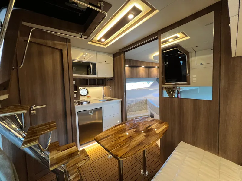 Slide: The Image of 2024 Evolve 400HT yacht interior with modern kitchen and cozy seating area. - 20