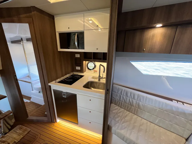Slide: The Image of Modern kitchen area in 2024 Evolve 400HT yacht with wood accents and stainless steel appliances. - 24