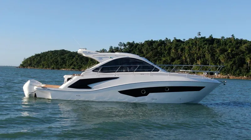 Slide: The Image of 2024 Evolve 400HT luxury yacht cruising on a serene lake with lush green island backdrop. - 3