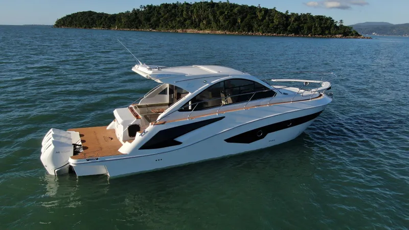 Slide: The Image of 2024 Evolve 400HT luxury yacht cruising on the ocean near a lush island. - 5