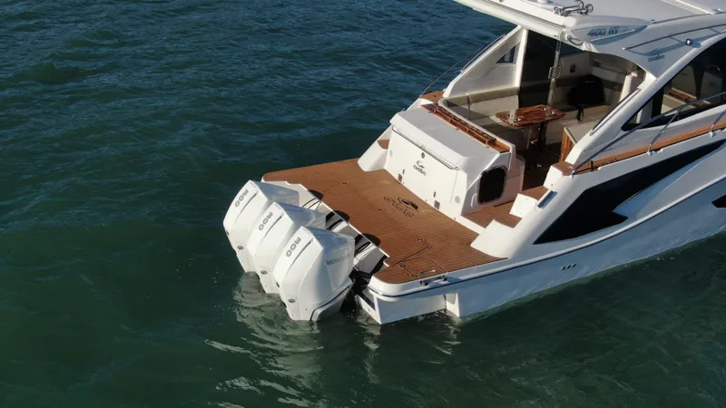 Slide: The Image of Evolve 400HT 2024 luxury yacht with twin outboard engines on water. - 9