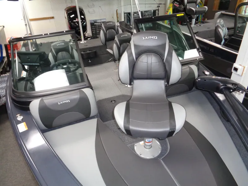 Slide: The Image of 2024 Lund 1775 Crossover XS boat displayed in a showroom with boating accessories. - 15