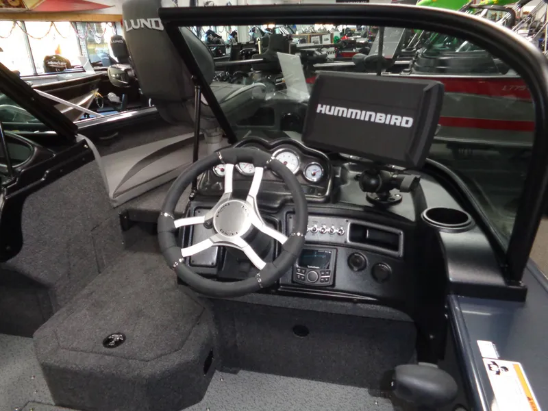 Slide: The Image of 2024 Lund 1775 Crossover XS boat interior with seating and motor. - 22