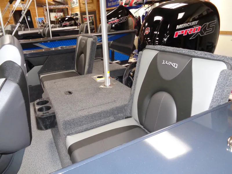 Slide: The Image of 2024 Lund 1775 Crossover XS boat interior with seating and windshield in showroom. - 7