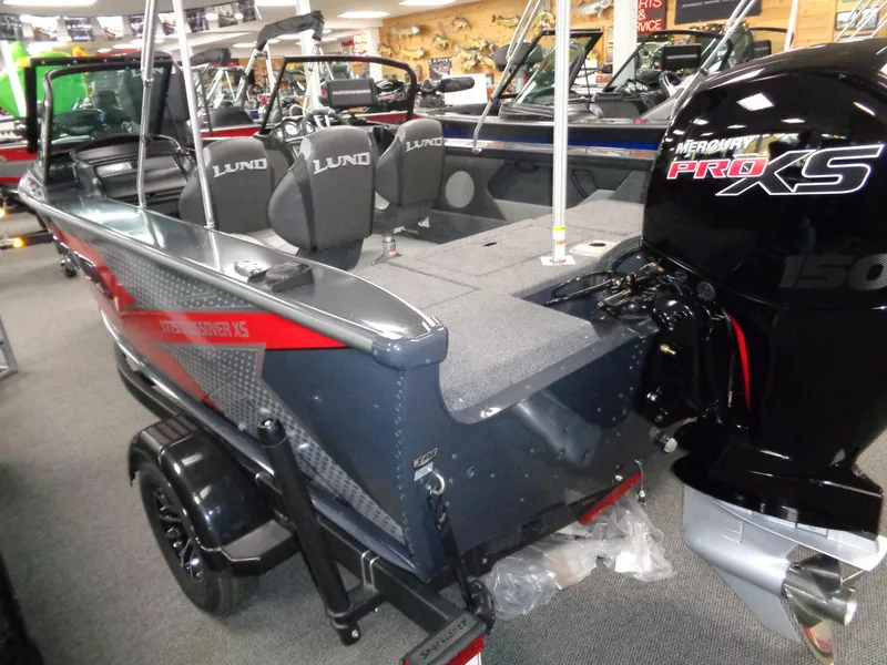 Slide: The Image of 2024 Lund 1775 Crossover XS boat interior with motor and seating area. - 8