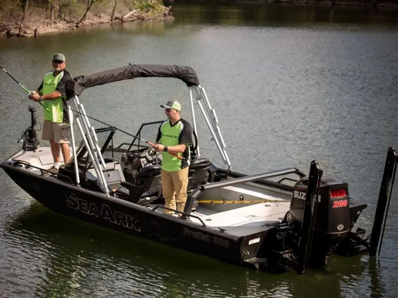 Slide: The Image of 2024 SeaArk ProCat 200 fishing boat on a calm lake with two anglers. - 13