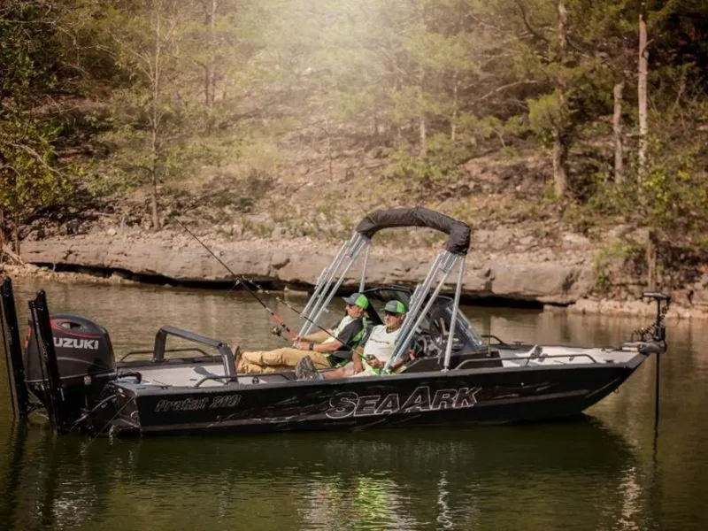 Slide: The Image of 2024 SeaArk ProCat 200 fishing boat on a serene lake. - 14