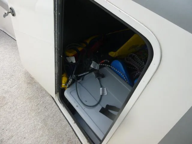 Slide: The Image of Storage compartment of 1992 Tiara Sport 250 boat with various equipment inside. - 21