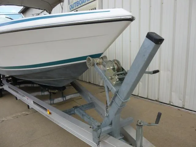 Slide: The Image of 1992 Tiara Sport 250 boat on trailer, parked near a building. - 8
