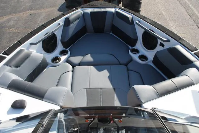 Slide: The Image of 2024 Malibu 20 VTX boat interior with gray seating and cup holders. - 12