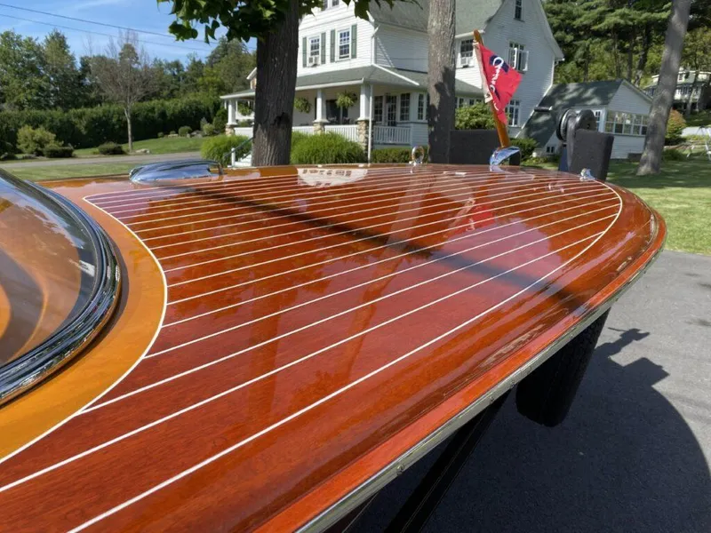 Slide: The Image of 1955 Chris-Craft Cobra 21 with polished wooden deck, parked near a house. - 28