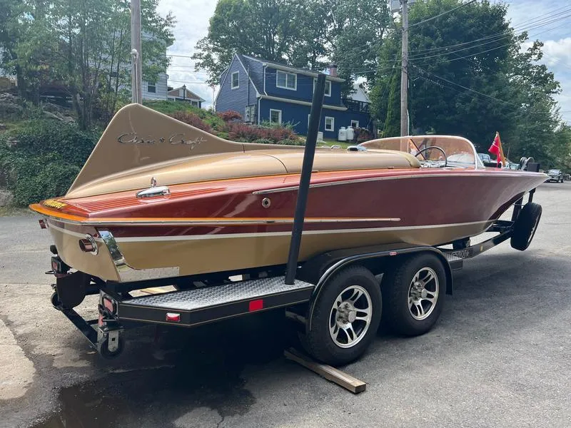 Slide: The Image of 1955 Chris-Craft Cobra 21 boat on trailer, classic design, parked outdoors. - 6