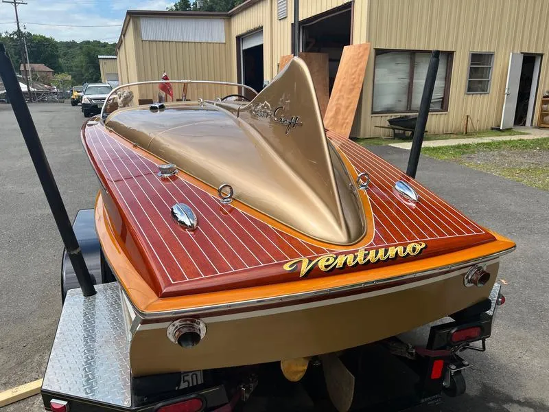 Slide: The Image of 1955 Chris-Craft Cobra 21 boat with wooden deck and gold accents on a trailer. - 7