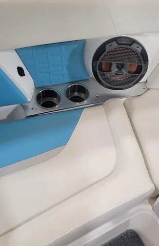 Slide: The Image of 2019 MasterCraft X22 interior with blue accents, speaker, and cup holders. - 13
