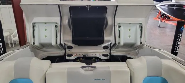 Slide: The Image of 2019 MasterCraft X22 boat interior with open storage compartments and seating. - 14