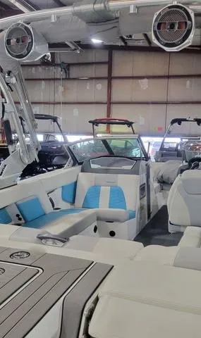 Slide: The Image of 2019 MasterCraft X22 boat interior with blue and white seating in a showroom. - 3