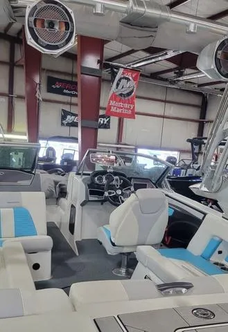 Slide: The Image of 2019 MasterCraft X22 boat interior in showroom with modern seating and controls. - 4