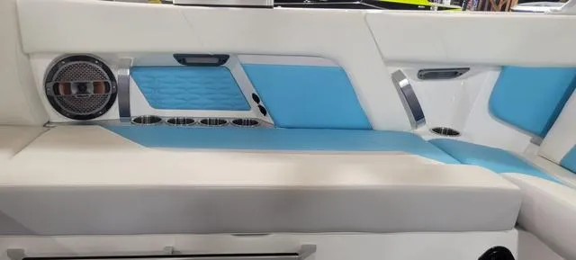 Slide: The Image of 2019 MasterCraft X22 interior with blue and white seating, speaker, and cup holders. - 5
