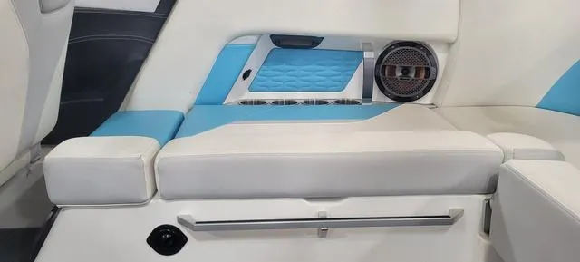 Slide: The Image of 2019 MasterCraft X22 interior with blue and white seating, speaker, and cup holders. - 6