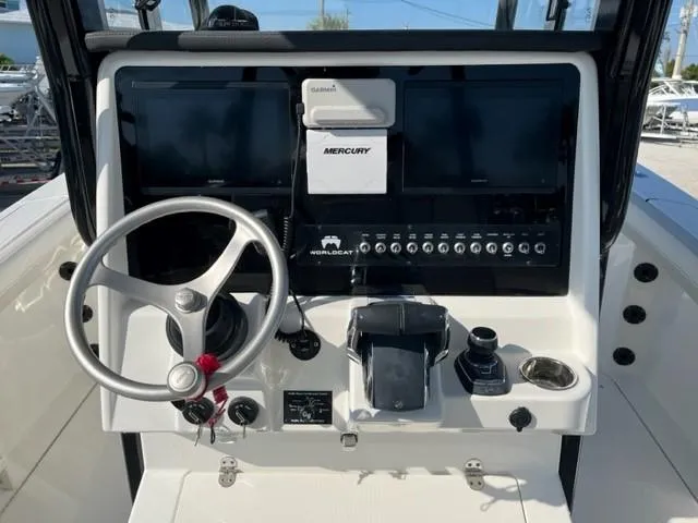 Slide: The Image of 2024 World Cat 295 CC boat dashboard with steering wheel and control panel. - 4