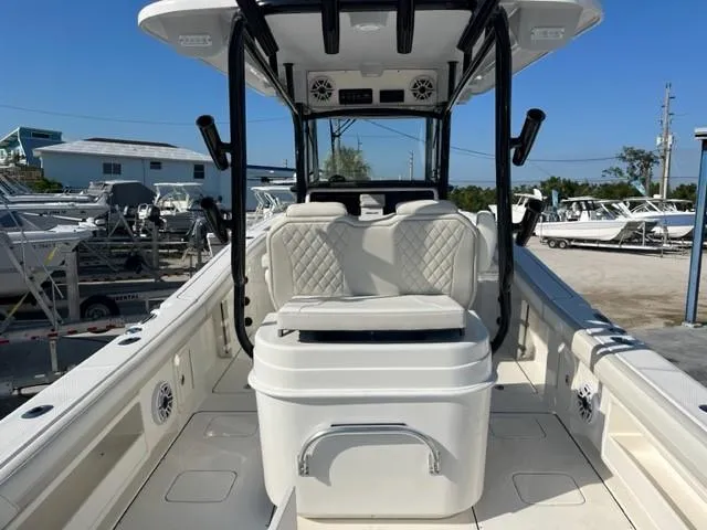 Slide: The Image of 2024 World Cat 295 CC boat interior with seating and storage, docked outdoors. - 5