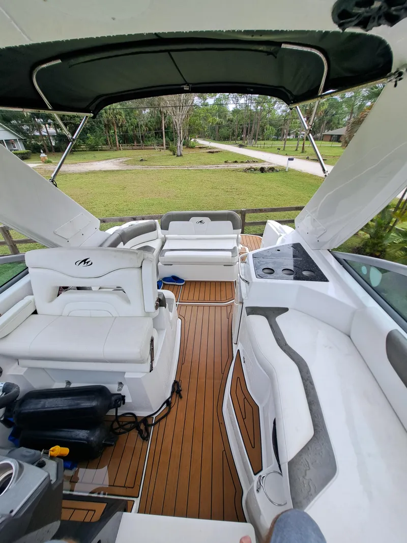 Slide: The Image of 2015 Monterey 295 Sport Yacht interior with white seating and wood flooring. - 10