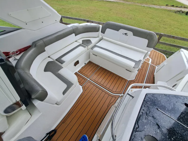 Slide: The Image of 2015 Monterey 295 Sport Yacht interior with white and gray seating, teak flooring. - 11
