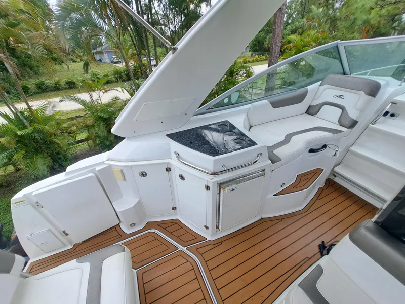 Slide: The Image of 2015 Monterey 295 Sport Yacht interior with seating and kitchenette. - 12