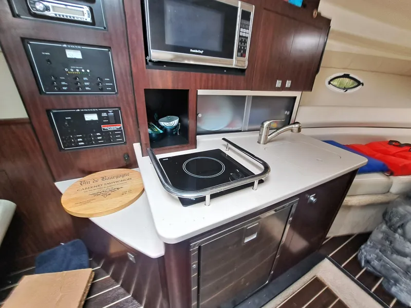 Slide: The Image of Interior kitchen area of a 2015 Monterey 295 Sport Yacht with stove, microwave, and sink. - 15