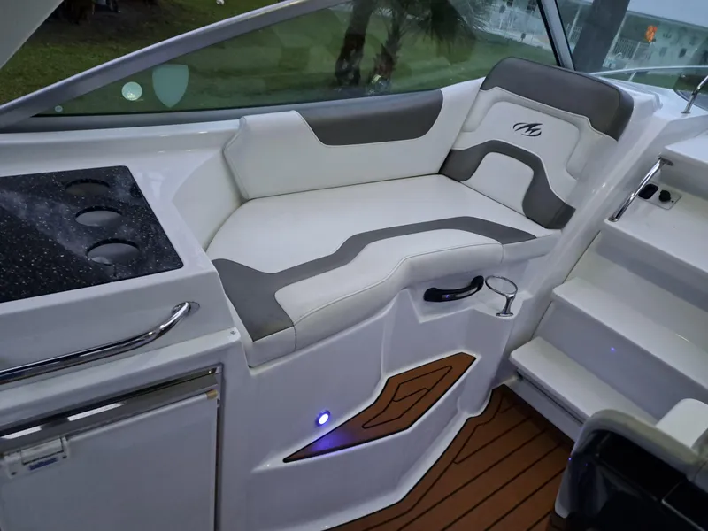 Slide: The Image of 2015 Monterey 295 Sport Yacht interior seating area with white and gray upholstery. - 18