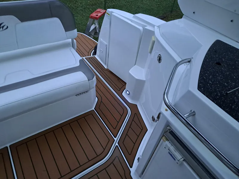 Slide: The Image of 2015 Monterey 295 Sport Yacht interior with teak flooring and white seating. - 24