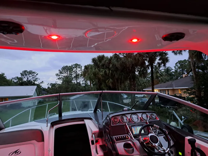 Slide: The Image of 2015 Monterey 295 Sport Yacht cockpit with illuminated dashboard and red overhead lights. - 8