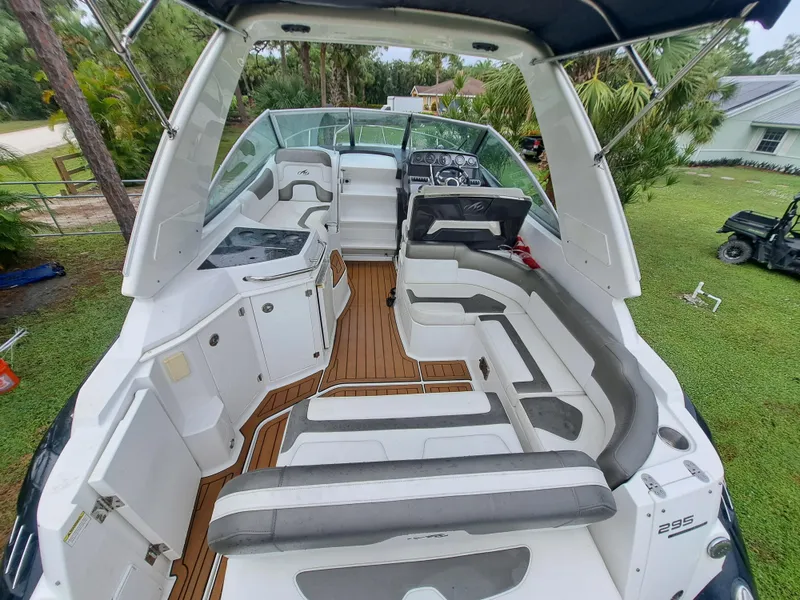 Slide: The Image of 2015 Monterey 295 Sport Yacht interior with white and gray seating, wood flooring. - 9