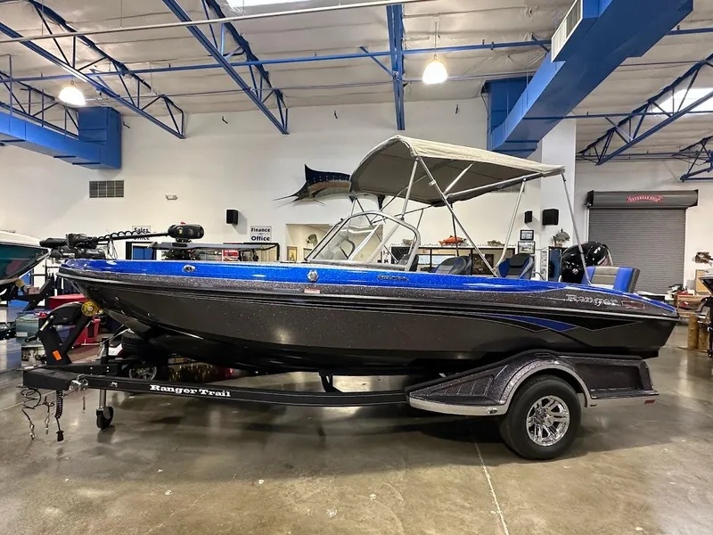 The Image of 2024 Ranger 1850MS boat in showroom, blue and black design, on trailer. - 1
