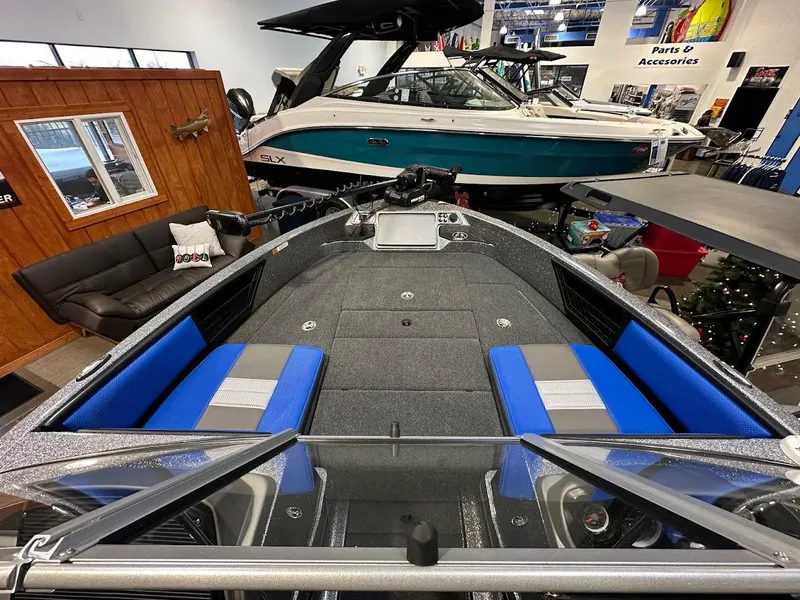 Slide: The Image of 2024 Ranger 1850MS boat interior with blue and gray seating in showroom. - 11