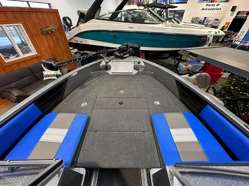 Slide: The Image of 2024 Ranger 1850MS boat interior with blue and gray seating, displayed in showroom. - 12