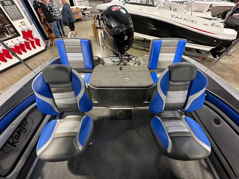 Slide: The Image of 2024 Ranger 1850MS boat interior with blue and gray seating, motor, and storage. - 16