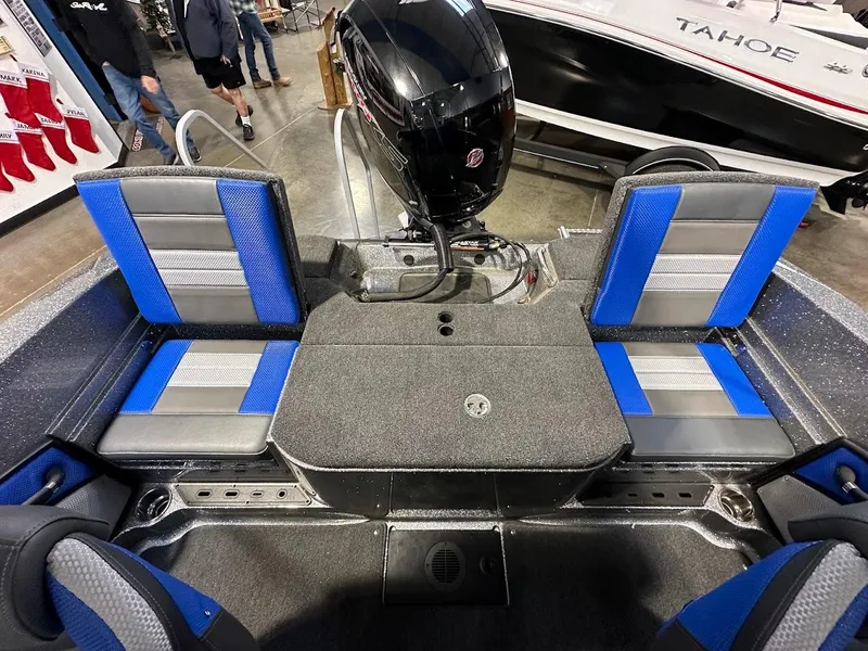 Slide: The Image of 2024 Ranger 1850MS boat interior with blue and gray seating, motor, and storage area. - 17