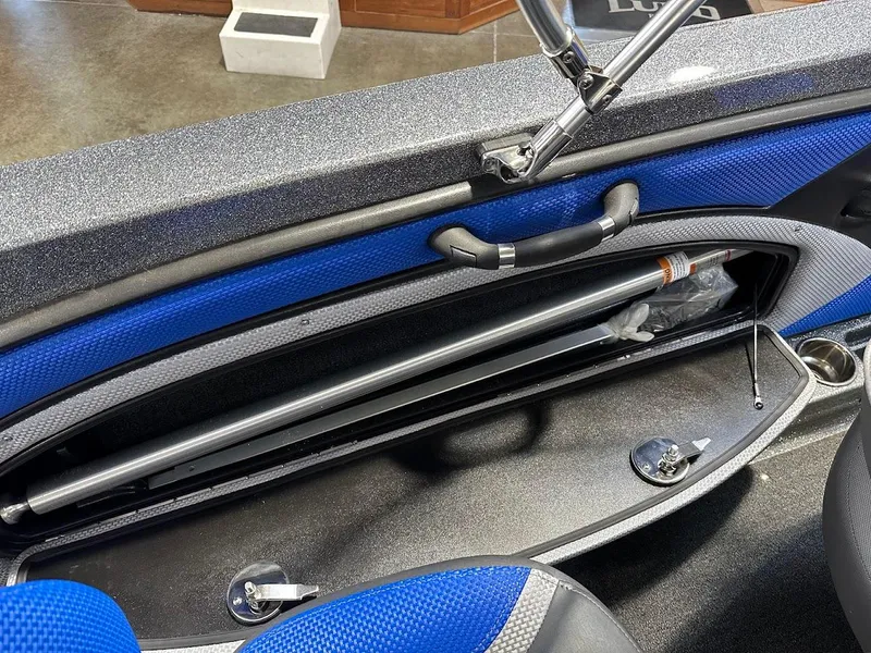Slide: The Image of 2024 Ranger 1850MS boat interior storage compartment with blue accents and secure fittings. - 35