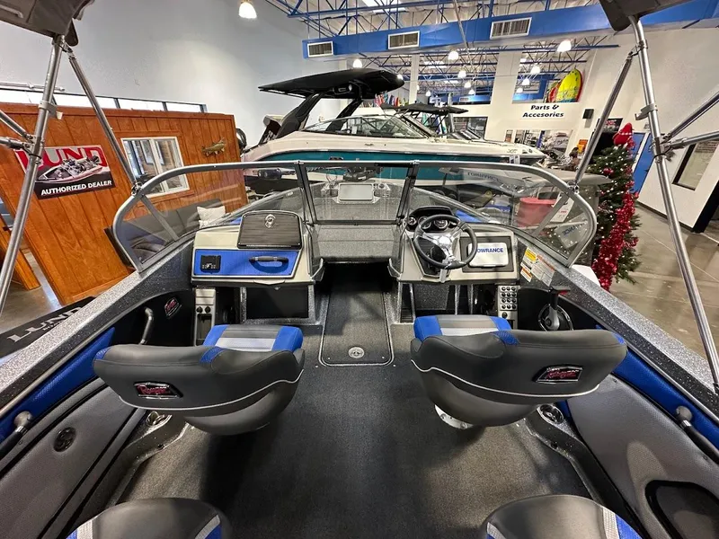 Slide: The Image of 2024 Ranger 1850MS boat interior with dual seats and modern dashboard in showroom. - 9