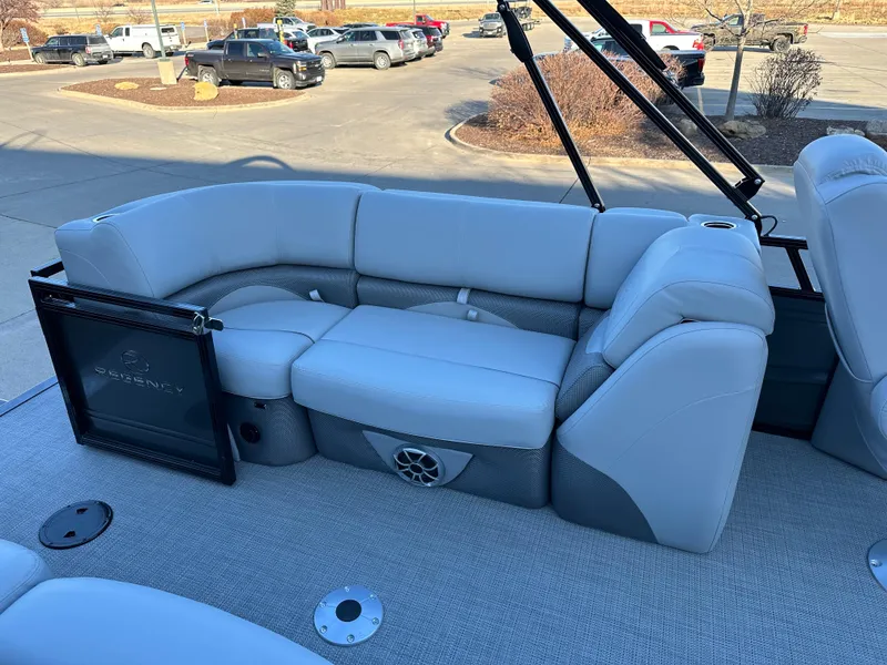 Slide: The Image of 2024 Regency 230 DL3 boat interior with plush seating in a parking lot. - 10