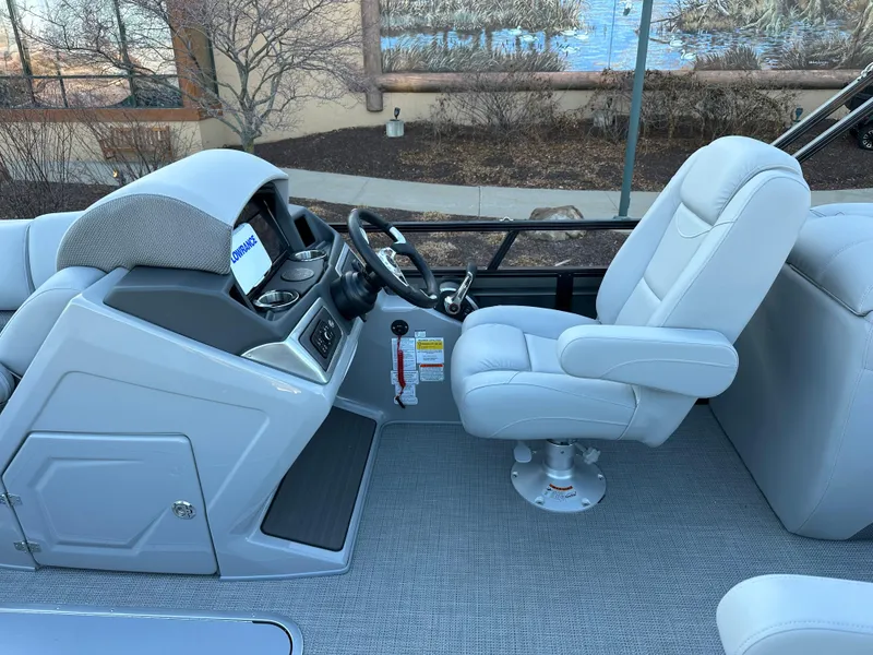 Slide: The Image of 2024 Regency 230 DL3 boat interior with captain's chair and steering console. - 7