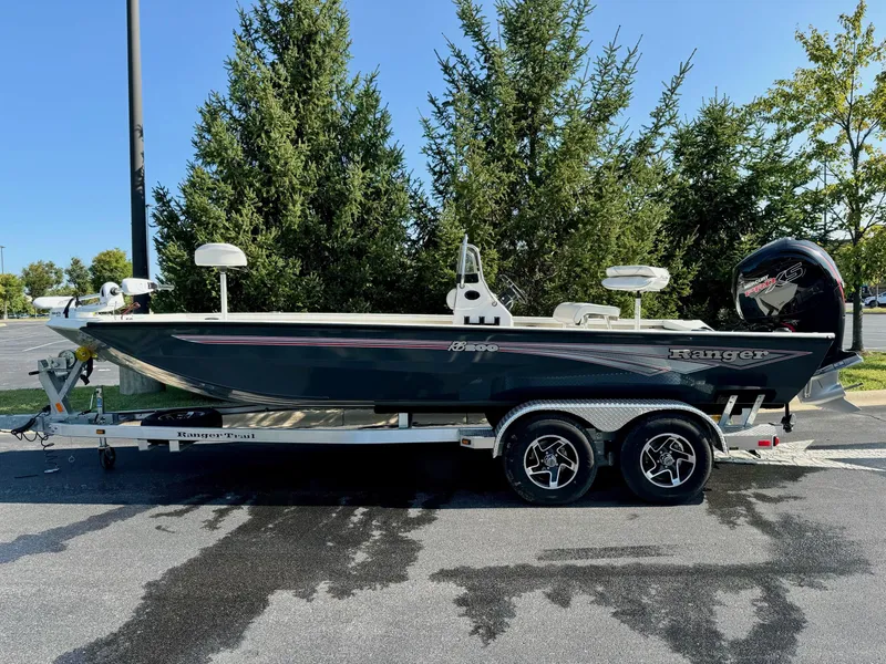 Slide: The Image of 2024 Ranger RB200 boat on trailer, parked outdoors, surrounded by trees. - 0