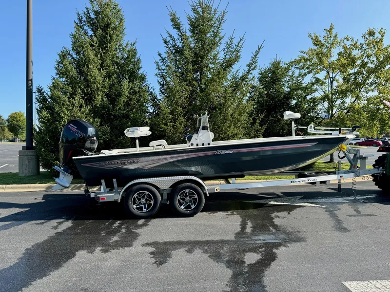 Slide: The Image of 2024 Ranger RB200 boat on trailer, parked outdoors, surrounded by trees. - 1
