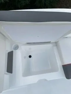 Slide: The Image of 2024 Tahoe T21 boat interior storage compartment with cup holder and drain. - 12