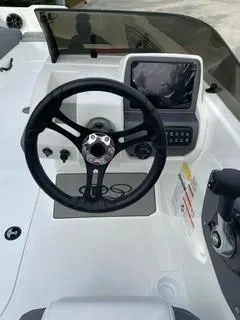 Slide: The Image of 2024 Tahoe T21 boat dashboard with steering wheel and navigation screen. - 8