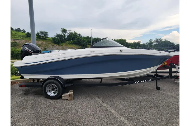 The Image of 2024 Tahoe 200 S boat on trailer, blue and white design, parked outdoors. - 0