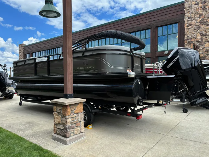 Slide: The Image of 2024 Regency 230 DL3 pontoon boat on a trailer outside a building. - 2