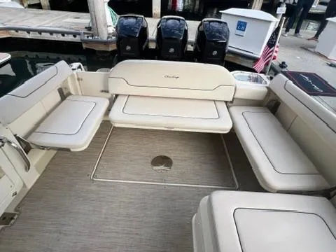 Slide: The Image of 2023 Chris-Craft Calypso 35 boat interior with beige seating and triple outboard motors. - 10