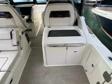 Slide: The Image of 2023 Chris-Craft Calypso 35 interior with seating and storage, docked by the water. - 14